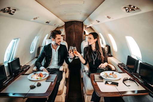 couple enjoys a meal and drinks while on private jet KHM Attorneys at Law Colorado Springs, Castle Rock