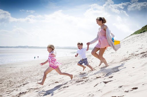 mother and two young children run in the sand toward the water KHM Attorneys at Law Colorado Springs, Castle Rock
