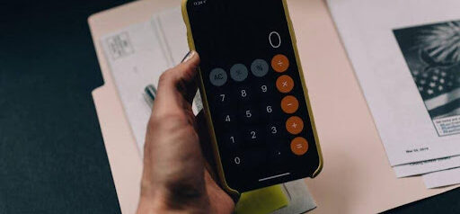 woman uses iPhone calculator to figure out her finanicals KHM Attorneys at Law Colorado Springs, Castle Rock