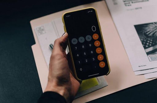 woman uses iPhone calculator to figure out her finanicals KHM Attorneys at Law Colorado Springs, Castle Rock