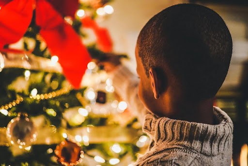 young boy puts holiday decorations on tree KHM Attorneys at Law Colorado Springs, Castle Rock