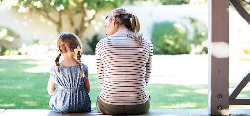 mother speaks to young girl with braids discussing divorce on the patio KHM Attorneys at Law Colorado Springs, Castle Rock