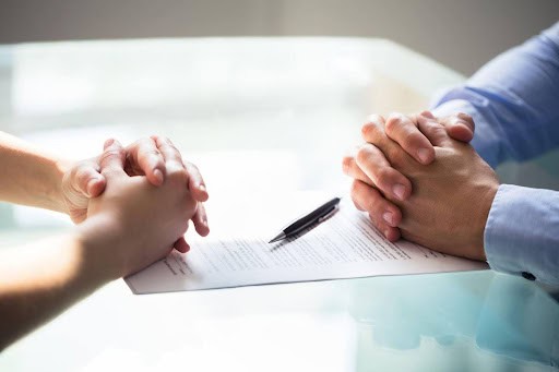 man and woman sit across from table with folded hands as they file for separation KHM Attorneys at Law Colorado Springs, Castle Rock