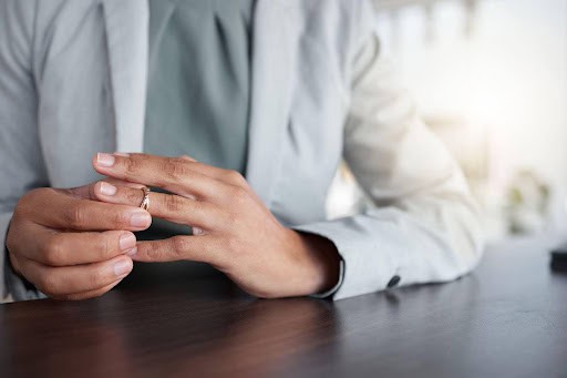 woman in office removes wedding ring as she focuses on healing KHM Attorneys at Law Colorado Springs, Castle Rock