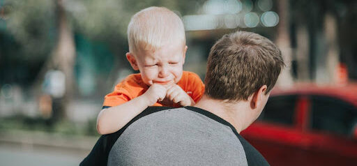 father carries upset son to a car KHM Attorneys at Law Colorado Springs, Castle Rock