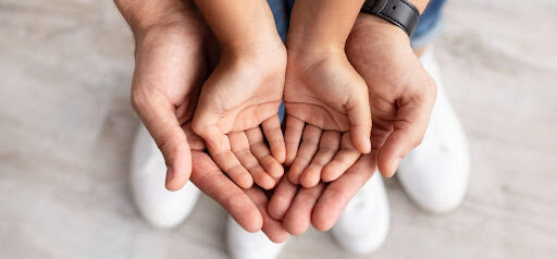 young child's hands open in father's open hands KHM Attorneys at Law Colorado Springs, Castle Rock