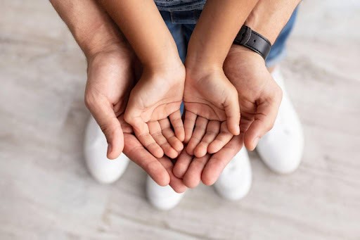 young child's hands open in father's open hands KHM Attorneys at Law Colorado Springs, Castle Rock