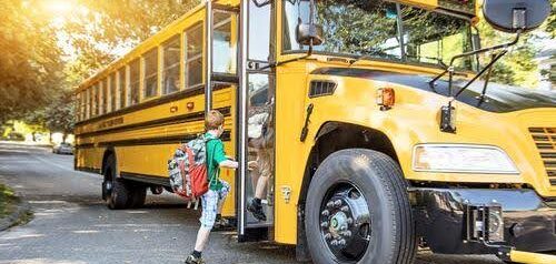 young boy in green shirt gets on school bus KHM Attorneys at Law Colorado Springs, Castle Rock