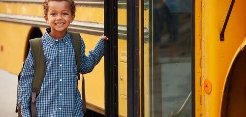 young child poses before getting on school bus KHM Attorneys at Law Colorado Springs, Castle Rock