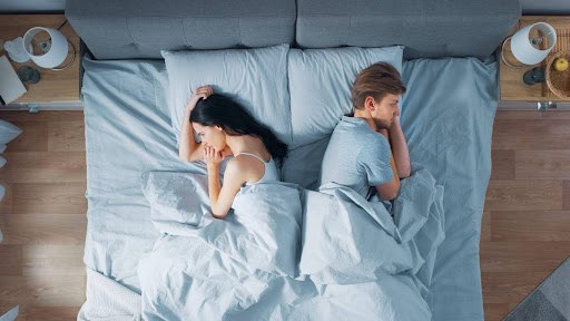 man and woman face opposite sides of bed thinking their marriage might be over KHM Attorneys at Law Colorado Springs, Castle Rock