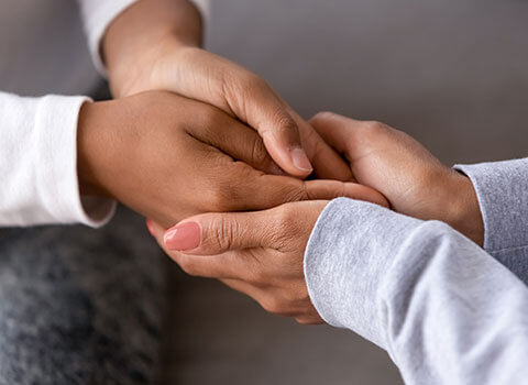 close up of woman holding hands of teenager showing support and care KHM Attorneys at Law Colorado Springs, Castle Rock