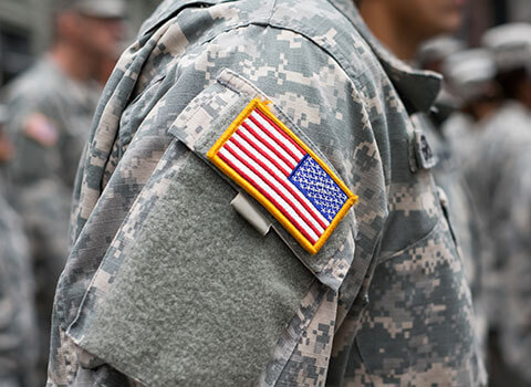 close up image of military officer wearing fatigues with American flag patch on arm KHM Attorneys at Law Colorado Springs, Castle Rock