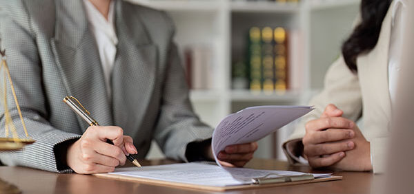 woman signs spousal maintenance paperwork in law office KHM Attorneys at Law Colorado Springs, Castle Rock