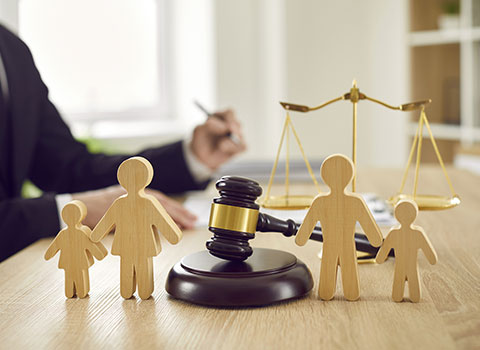 hero image close up of wood cutouts of two parents and two children with gavel in representing a separation KHM Attorneys at Law Colorado Springs, Castle Rock